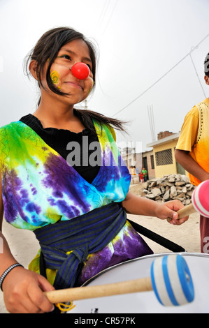 Girl with a drum wearing a clown nose, Arena y Esteras project, teenagers marching through the streets dressed up as street Stock Photo