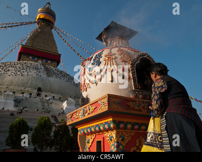Old woman performing a religious ceremony in front of Boudnath stupa, Boudnath, Kathmandu, Nepal, South Asia Stock Photo