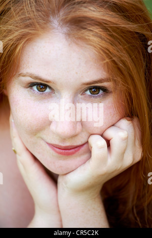 Portrait of a beautiful 20 year old redhead woman looking at camera and smiling. Stock Photo