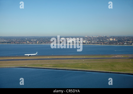 Plane landing at Sydney Airport, and Botany Bay, Sydney, New South Wales, Australia - aerial Stock Photo