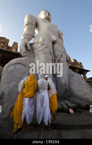 A group of Jain pilgrims doing a special pooja to receive the blessings of Bahubali by the local priests, in front of the statue Stock Photo