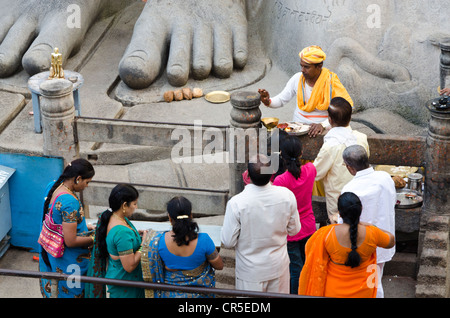 Pilgrims receive the blessings of Bahubali by a local priest on Indragiri hill in Sravanabelagola, Karnataka, India, Asia Stock Photo