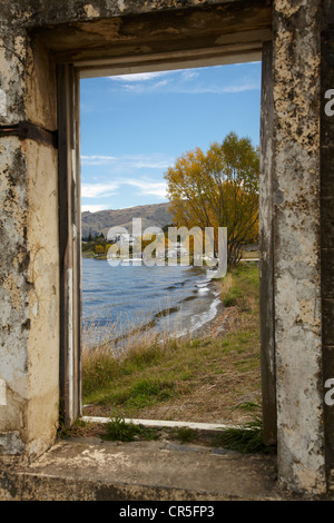 Looking through window of derelict building to Lake Dunstan and Old Cromwell Town, Cromwell, Central Otago, New Zealand Stock Photo