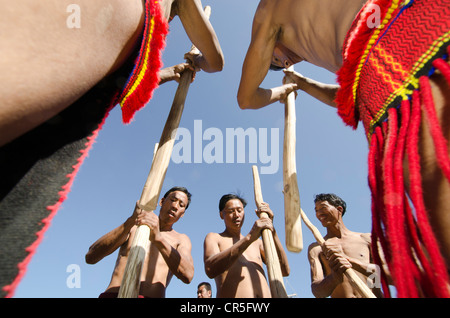 Members of the Samdom tribe show their traditional way of crushing crops at the annual Hornbill Festival, Kohima, Nagaland Stock Photo