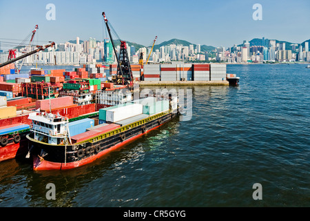 Cranes loading containers onto lighters in Hong Kong's Victoria Harbour. Stock Photo