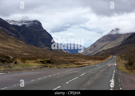 road coming from rannoch moor leading to fort william via glencoe in the highlands of scotland with snow capped mountains Stock Photo