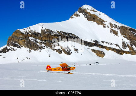 Takeoff of a Piper PA-18 Super Cub on the snow-covered Glacier de Tsanfleuron mountain airfield at the foot of Oldenhorn Stock Photo