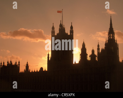 A Union Jack flag flying above the silhouetted Houses of Parliament, London, United Kingdom. Stock Photo