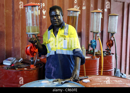 Fuel station owner stands between petrol barrels, Arawa, Autonomous Region of Bougainville, Papua New Guinea Stock Photo