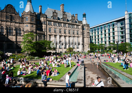 People relaxing in the heat in the Peace Gardens in front of Sheffield Town Hall. Stock Photo