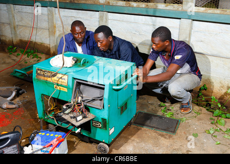 Mechanics repairing an emergency power generator, hospital, Manyemen, Cameroon, Africa Stock Photo