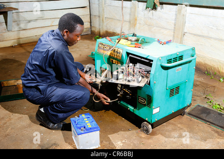 Mechanic repairing an emergency power generator, hospital, Manyemen, Cameroon, Africa Stock Photo