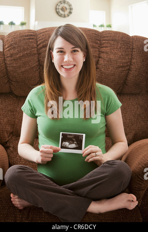 Portrait of pregnant woman showing ultrasonography scan Stock Photo