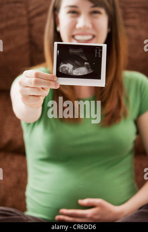 Portrait of pregnant woman showing ultrasonography scan Stock Photo