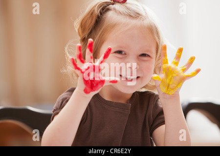 Girl (2-3) with paint covered hands Stock Photo