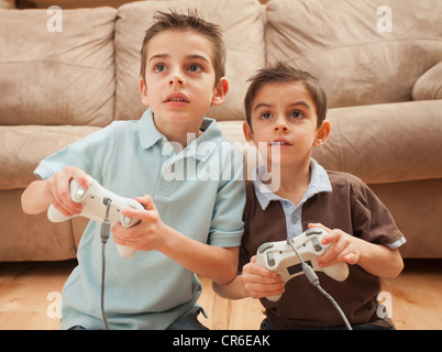 Front view of two boys (6-7, 8-9) playing Video Games Stock Photo