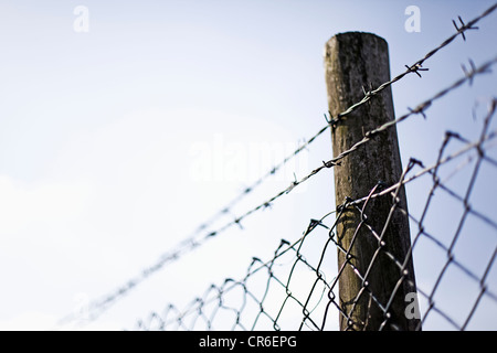 Germany, North Rhine Westphalia, Neuss, Wire mesh fence with pole against sky Stock Photo