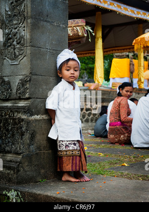 A young Balinese boy poses in traditional dress for a photo during a Hindu Temple anniversary called an Odalan. Stock Photo