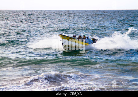 speeding fishing boat coming ashore in Baja Mexico near 'Todos Santos' Baja Mexico Stock Photo