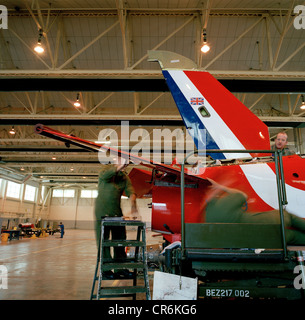 Engineer ground staff perform scheduled maintenance to a Hawk jet in the hangar of the Red Arrows, Britain's RAF aerobatic team. Stock Photo