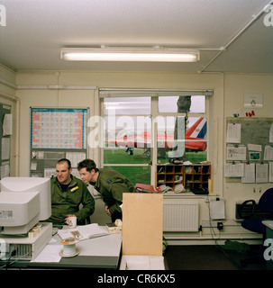 Engineering ground staff of the Red Arrows, Britain's RAF aerobatic team, consult technical information on Mod computers. Stock Photo