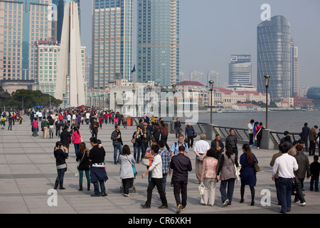 People walking along China, Shanghai, Huangpu River and tourists taking photos. Stock Photo