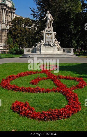 Statue of Wolfgang Amadeus Mozart, flowers shaping a French violin clef in the foreground, Burggarten park, Vienna, Austria Stock Photo