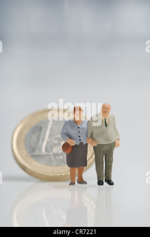Senior couple figurines in front of euro coin Stock Photo