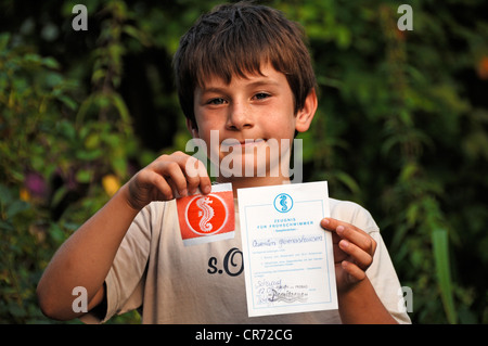 Boy, 7, proudly showing his seahorse badge and certificate for early swimmers, Germany, Europe Stock Photo