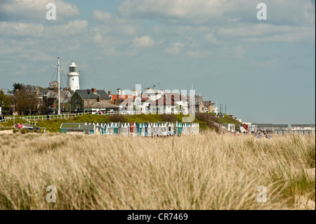 View of Southwold lighthouse from beach including row of Beach Huts Stock Photo