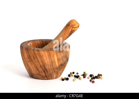 Iranian olive wood mortar for grinding spices, pepper corns next to it Stock Photo