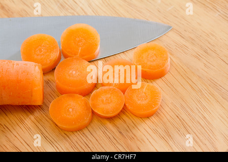 Sliced carrot on wooden chopping board Stock Photo