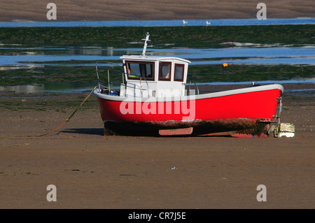 A small red boat at low tide on the River Torridge estuary Devon UK Stock Photo