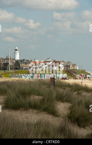 View of Southwold lighthouse from beach including row of Beach Huts Stock Photo