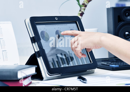 Female hand touching on modern digital tablet pc at the workplace. Stock Photo