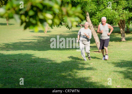 Active retirement, senior couple running and exercising in city park. Copy space Stock Photo