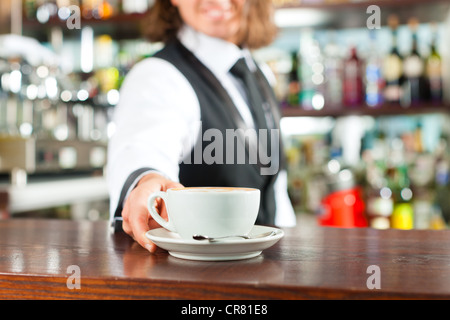 Barista making cappuccino in his coffeeshop or cafe Stock Photo