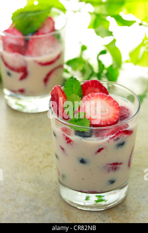 Vanilla yogurt with strawberries, blueberries and lemon balm Stock Photo