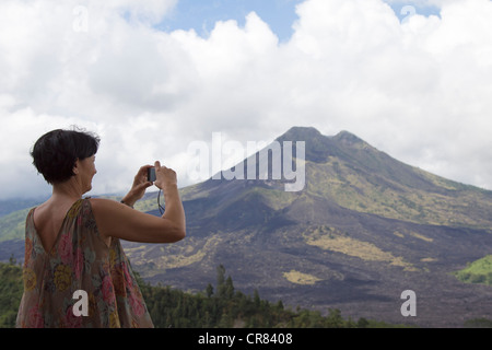 Tourist taking photo of Mount Gunung Batur Volcano from Kintamani - Bali - Indonesia Stock Photo