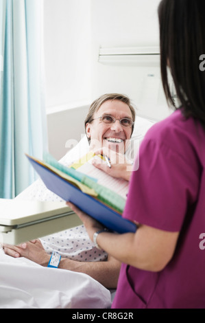 Nurse tending to patient in hospital bed wearing oxygen mask Stock ...