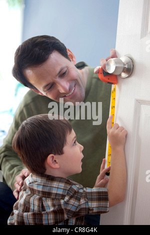 Father and son measuring door at home Stock Photo