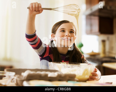 Girl mixing cake batter in bowl Stock Photo