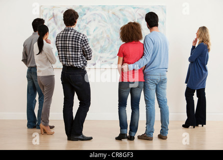 Men and women looking at oil painting in art gallery Stock Photo