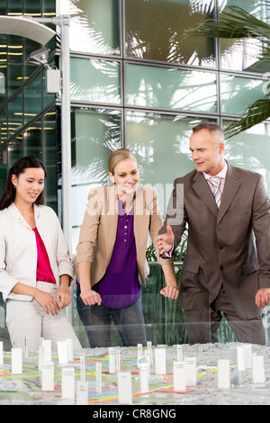 Architects talking in front of model of city Stock Photo
