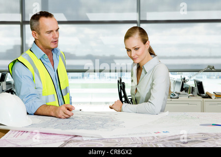 Engineer with architect looking at blueprints in office Stock Photo