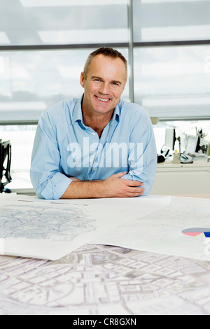 Portrait of an architect working on blueprints in office Stock Photo