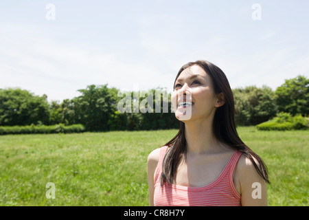 Mid-adult woman in a field, looking up