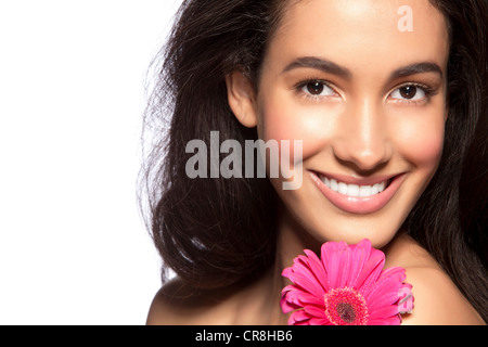 Young woman holding pink flower against white background Stock Photo