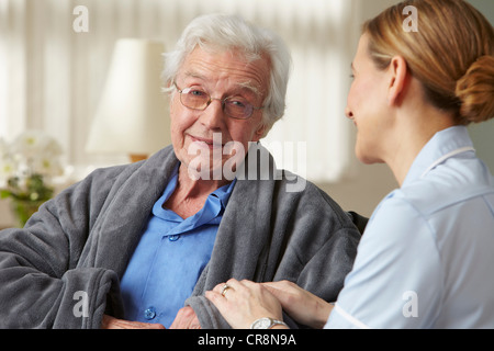 Carer touching senior mans arm Stock Photo