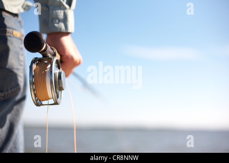 Fisherman holding a fly rod Stock Photo